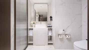 A modern bathroom with a large mirror, a toilet, and a shower area.