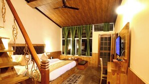 Ein Schlafzimmer mit Holzboden, einem Bett, einem Schreibtisch, einem Fernseher und einem Fenster mit Vorhängen.