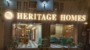 Una tienda Heritage Homes con entrada a cuadros, plantas en macetas y un mostrador de recepción visible.