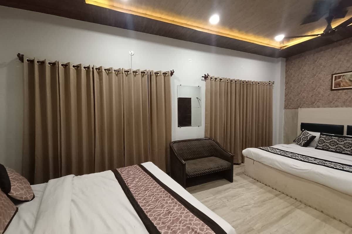 A hotel room with a bed, a chair, and curtains.
