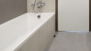 A modern bathroom with a bathtub, two sinks, and a shower. - HomesGetaway- 2BR in 1Residence at Wasl1 (Dubai)