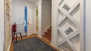 A hallway with a staircase, a glass door, and a fire extinguisher.
