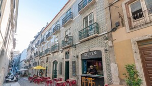 A narrow street with outdoor seating at a bar named 'Eleven Bar'.