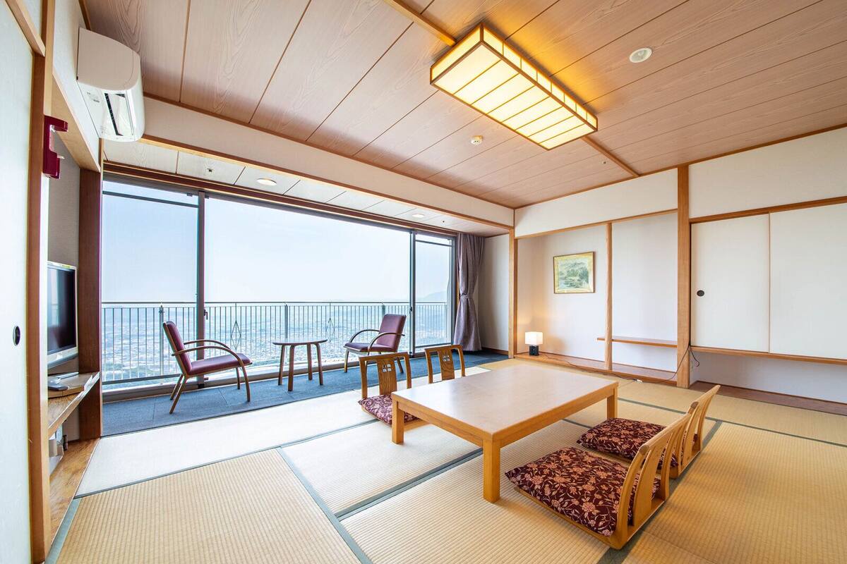 Een traditionele Japanse kamer met tatami vloerbedekking, een lage tafel en stoelen.