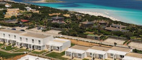 Um resort com piscina, praia e vista para o oceano.