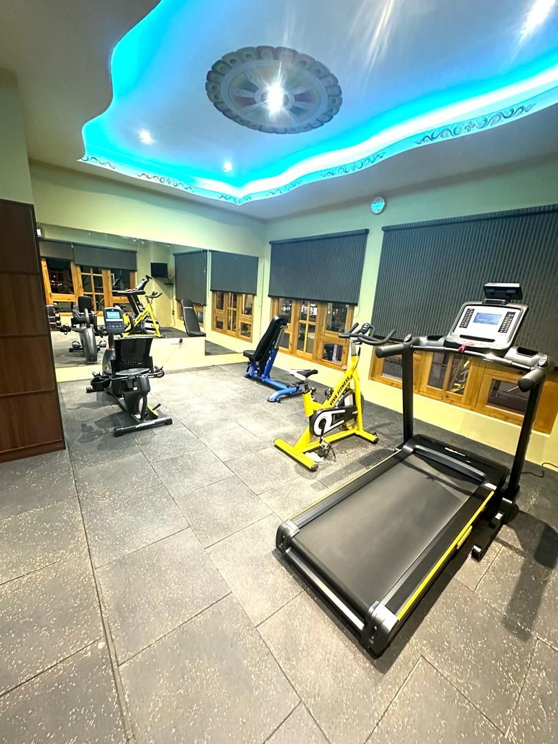 Un gimnasio con equipo de ejercicio, incluyendo cintas de correr y bicicletas estáticas.