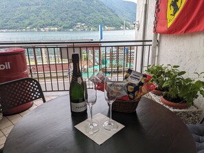 Ein Balkon mit einer Flasche Ferrari Brut Champagner, einem Glas, Snacks und Topfpflanzen.