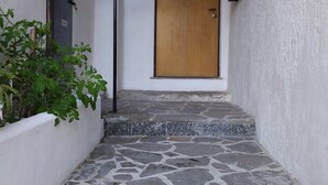 A narrow stone-paved corridor leading to a wooden door with a sign above it. - Il Cavallino vacation home on Lake Ceresio and Lugano (Lombardia)