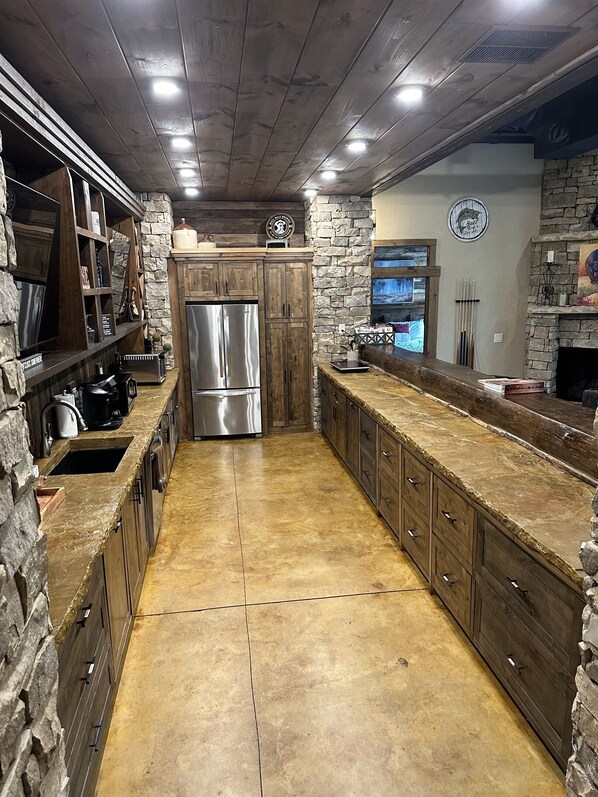 Una cocina con una isla central, armarios de madera y una pared decorativa de piedra.