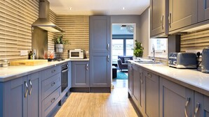 A modern kitchen with grey cabinets, a microwave, and a toaster. - Twickenham Green (Twickenham)