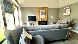 A modern living room with a grey sofa, a television, and artwork on the wall. - Twickenham Green (Twickenham)