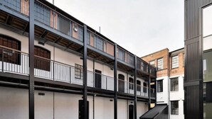 A multi-story building with balconies and large windows.