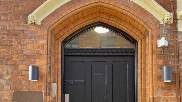 A brick building with a black arched entrance and a door labeled "One Five Six 156". - OneFiveSix Unique ApartHotel 2-Bed 2-Bathroom (Birmingham)
