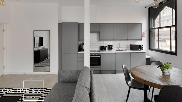 A modern apartment with a living room, kitchen, and dining area. - OneFiveSix Unique ApartHotel 2 Bed (West Midlands)