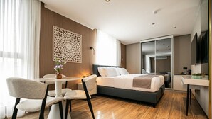 Een moderne hotelkamer met een bed, een bureau en een stoel.