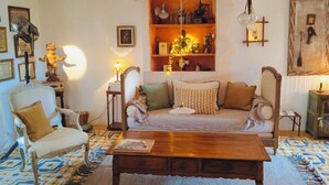Ein gemütliches Wohnzimmer mit einer Couch, Sesseln, einem Holztisch und Dekorationselementen.