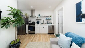 A modern kitchen with white cabinets, stainless steel appliances, and a central island.