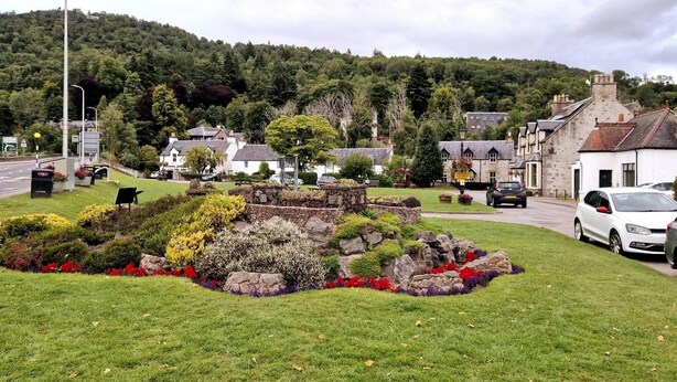 A rural setting with stone structures, a white building, and a road. - Luxury 3-bed House in the Scottish Highlands (Inverness)
