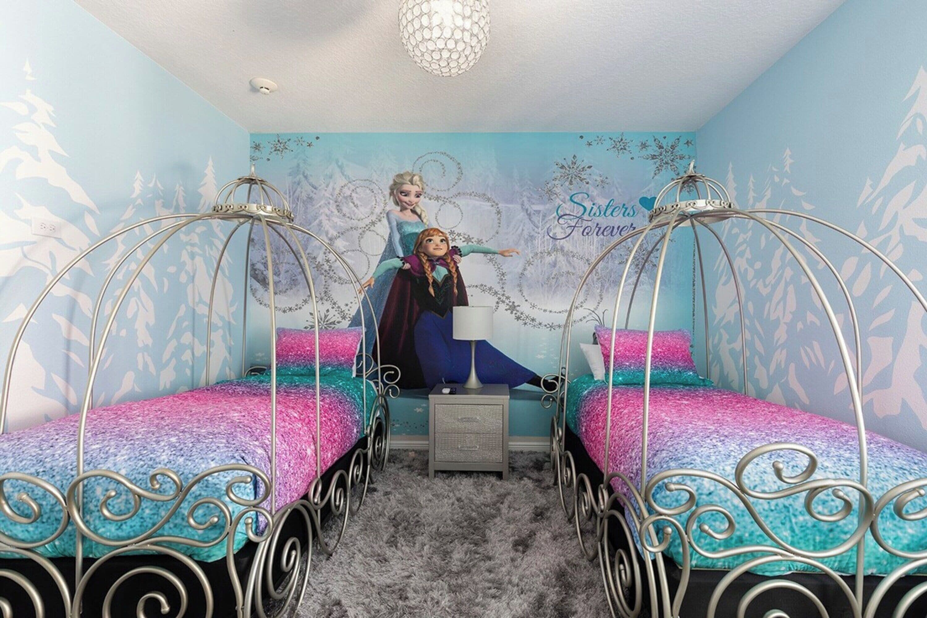 Une chambre à coucher avec deux lits à structure métallique, une petite table de chevet et une fresque murale.