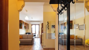 Amplia sala de estar con sofá, una mesa de comedor y una cocina al fondo.