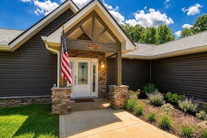 A building with a stone facade, a white door, and an American flag. - Broadview, River, Golf Course, Games, free Attraction Tickets, WIFI!!! (Kodak)
