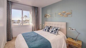 Quarto com cama, cortinas, mesa de cabeceira e decoração na parede.