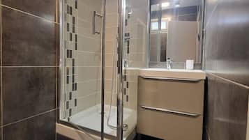 Een douche, handdoeken, toiletpapier