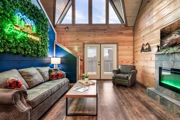 Relax in the inviting living room with a leather sofa, armchair, and fireplace.
