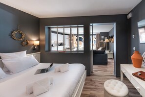 Una habitación de hotel moderna con una cama grande, un escritorio y vistas al comedor.