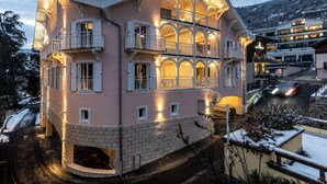 A multi-story hotel with balconies, a brick facade, and a snow-covered landscape.