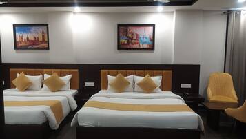 A hotel room with two beds, a chair, and artwork on the walls.