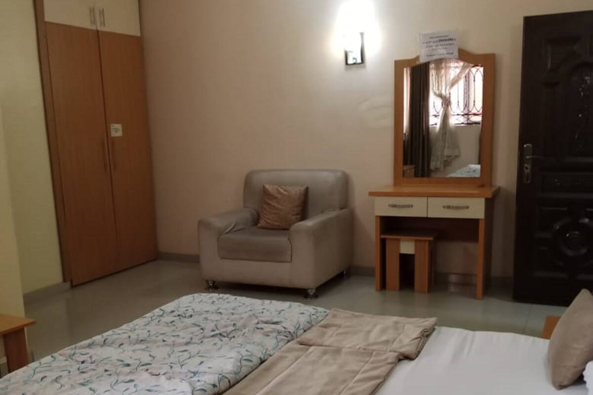 Une chambre à coucher comprenant un lit, une chaise, un bureau et une armoire.