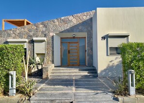 A modern building with a stone facade, a wooden door, and a number 29 on the wall.