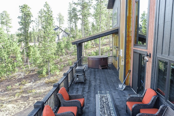 A wooden deck with outdoor seating, a hot tub, and a view of a forested area. - Incredible Views from Spacious Hillside Lodge Access to Clubhouse w/ 2 Pools (Lead)