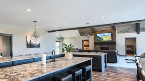 A modern kitchen with a large island, bar stools, and pendant lighting. - 6400+ Sq. Ft. Beautiful New Lodge in Powder House Pass w/ Comm. Pool Access! (Lead)