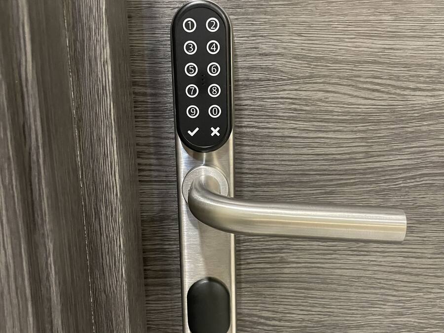 Ein modernes Türschloss mit Zahlencode-Tastatur und einem Schwenkgriff.