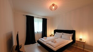 A bedroom with a bed, a TV, a bedside table, and a lamp. - 2 bedroom apartment in herrsching am ammersee (Herrsching am Ammersee)
