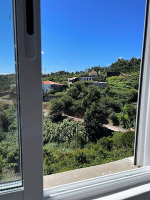 A view of a hillside with buildings and greenery.