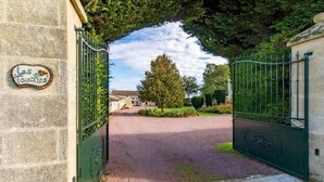 A gated entrance with a stone wall and a sign reading 'Les Touches.' - Anjou - Manoir Les Touches (Doué-en-Anjou)