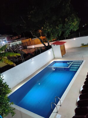 A rectangular swimming pool with a blue interior, surrounded by a white wall and a concrete deck. - Vacacional exclusive house for family group and friends,5 min from the Beach (Atacames)