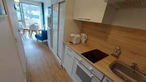 A modern kitchen with a built-in oven, a sink, and a coffee maker.