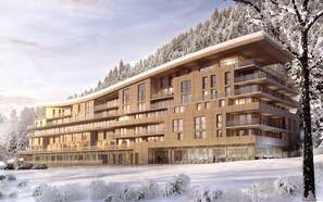 A multi-story hotel with balconies, a stone facade, and a snowy landscape. - 50m from ski slopes, fitness, swimming pool, sauna, hammam, terrace, ski locker, 75m², Les Arcs (Bourg-Saint-Maurice)