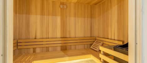 Una sauna de madera con bancos y calentador.