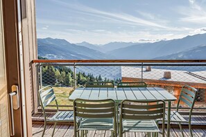 A balcony with a table and chairs, overlooking a mountainous landscape. - 50m from ski slopes, fitness, swimming pool, sauna, hammam, terrace, ski locker, 75m², Les Arcs (Bourg-Saint-Maurice)