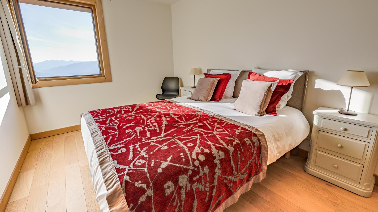 Une chambre à coucher avec un lit, des tables de chevet et une fenêtre.
