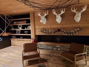 A cozy lobby with wooden walls, a fireplace, and two leather chairs. - 50m from ski slopes, fitness, swimming pool, sauna, hammam, terrace, ski locker, 75m², Les Arcs (Bourg-Saint-Maurice)