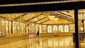 A spacious, well-lit hall with rows of seating and ornate golden decor. - Hotel shimla hills international (Theog)