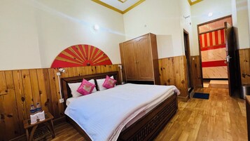 Un dormitorio con una cama de madera, un armario de madera y una puerta a rayas rojas y blancas.