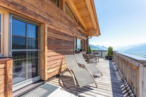 A wooden cabin with a balcony, large windows, and a view of mountains. - Beim Naglbauer (Piesendorf)