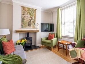 Cozy living room with a fireplace, comfortable seating, and a flat-screen TV.